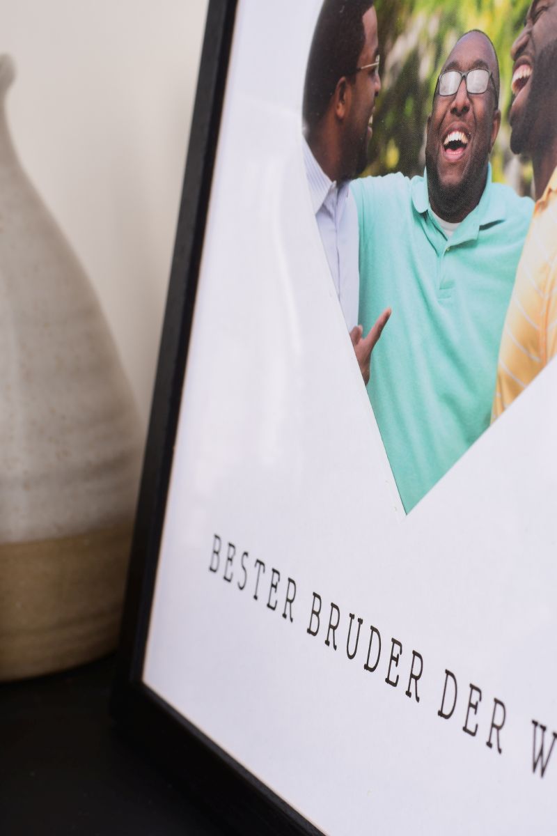 Primer plano de un marco de fotos de 30x30 en negro con un recorte de corazón para el mejor hermano del mundo.